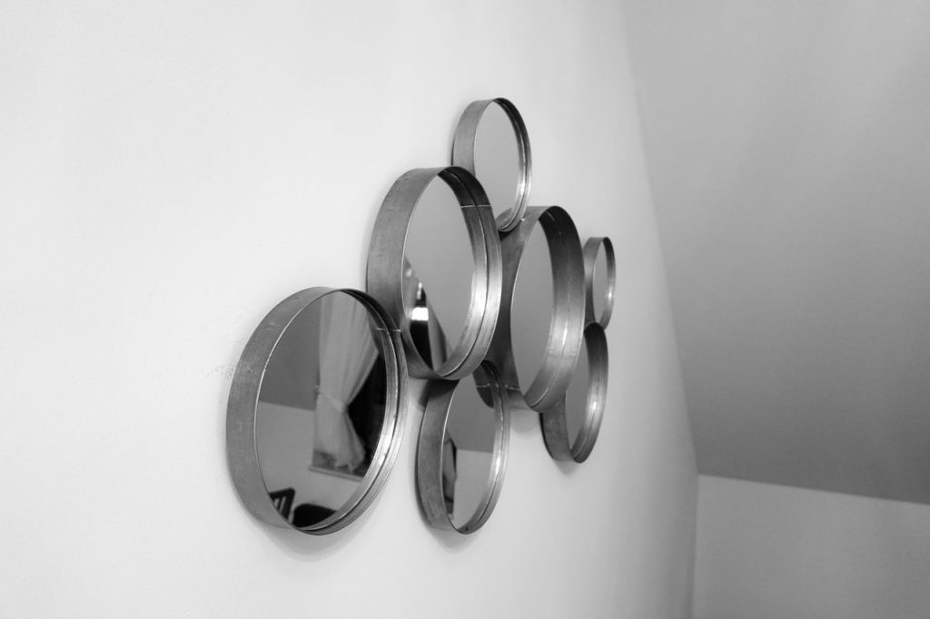 A collection of round mirrors on a white wall, perfect for modern home decor and interior design.